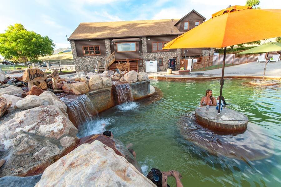 crystal hotsprings with yellow umbrella with table in spring in utah - photo by OnlyInYourState