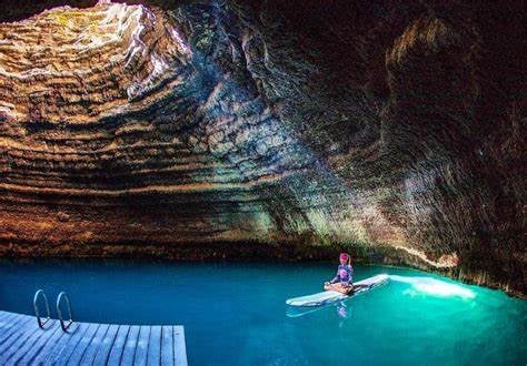 female paddleboarder on homestead crater inside pool in midway utah - photo by Visit Utah