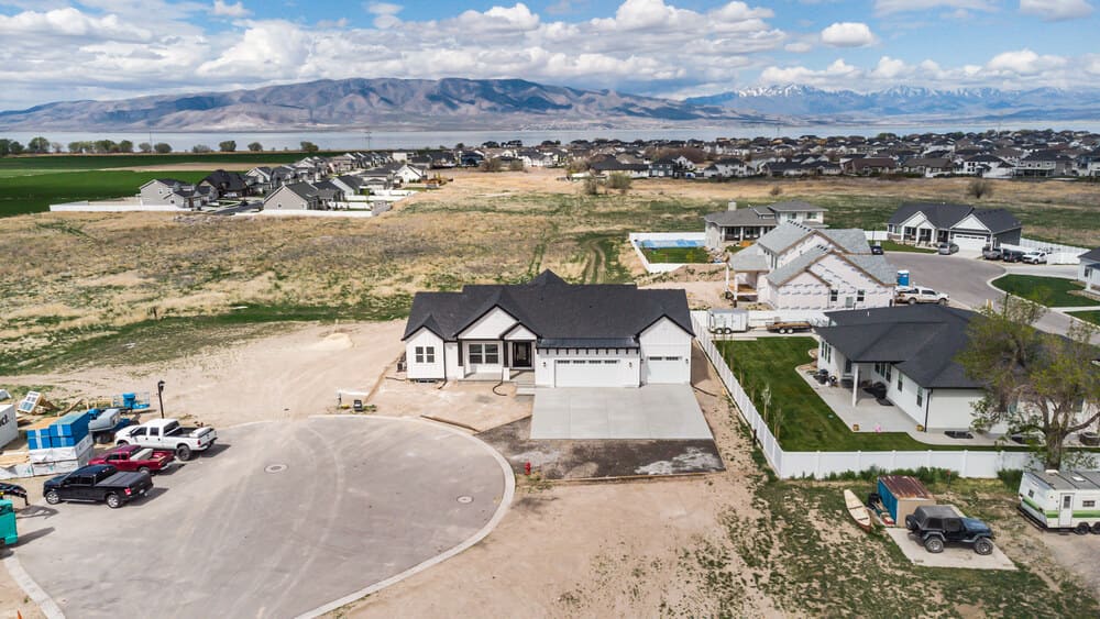 white custom home in Utah lot with mountains in background by 10x builders in utah