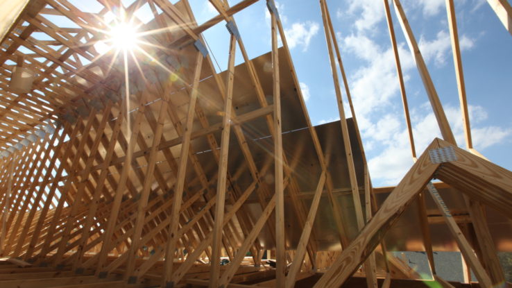 roofing being installed on new custom home frame - photo by build gp