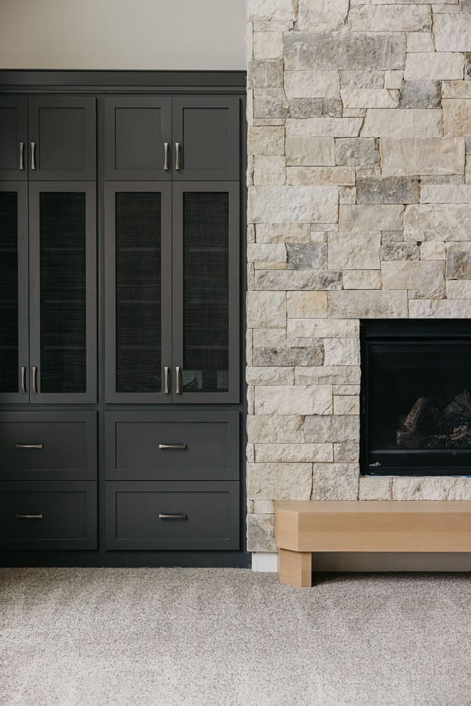 stone fireplace with black cabinets by 10x builders in utah county