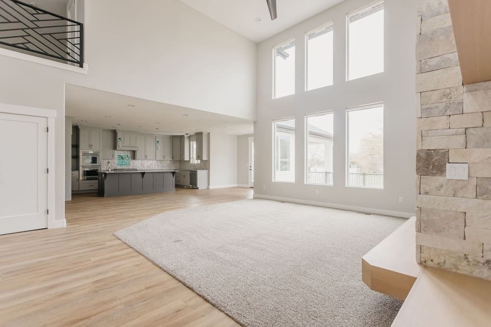 living area with large windows & carpet by 10x builders in utah county