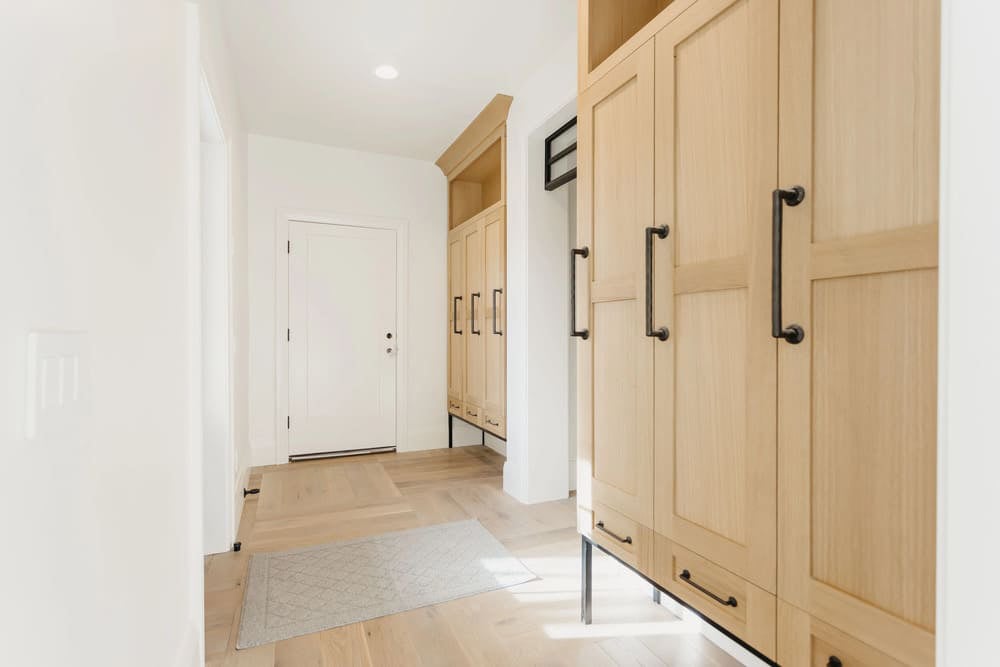 mudroom with light wood cabinets & dark handles by 10x builders in utah county