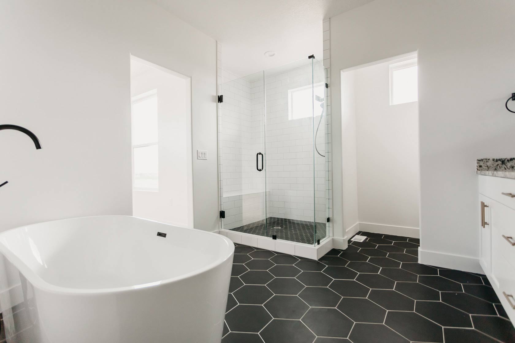 main bathroom with black & white hexagon tile by 10x builders in utah county