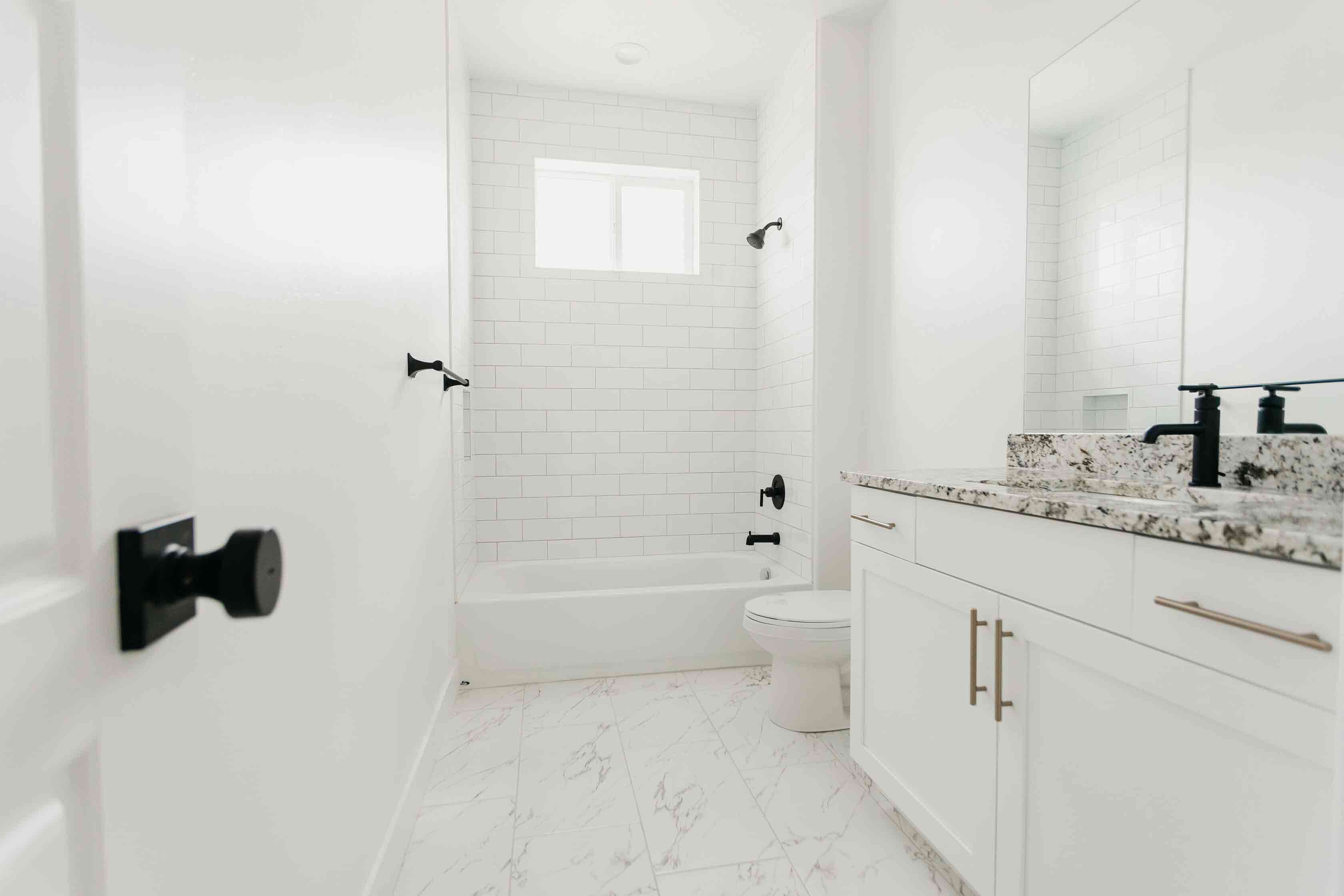 white guest bathroom with black details by 10x builders in utah county